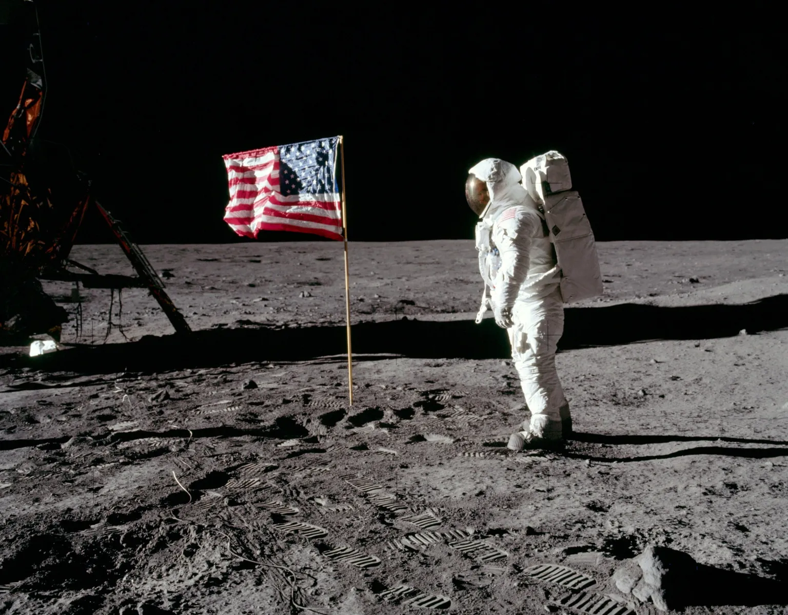 O astronauta Buzz Aldrin está em pé na Lua, de frente para uma bandeira dos EUA, durante a missão Apollo 11, em julho de 1969.